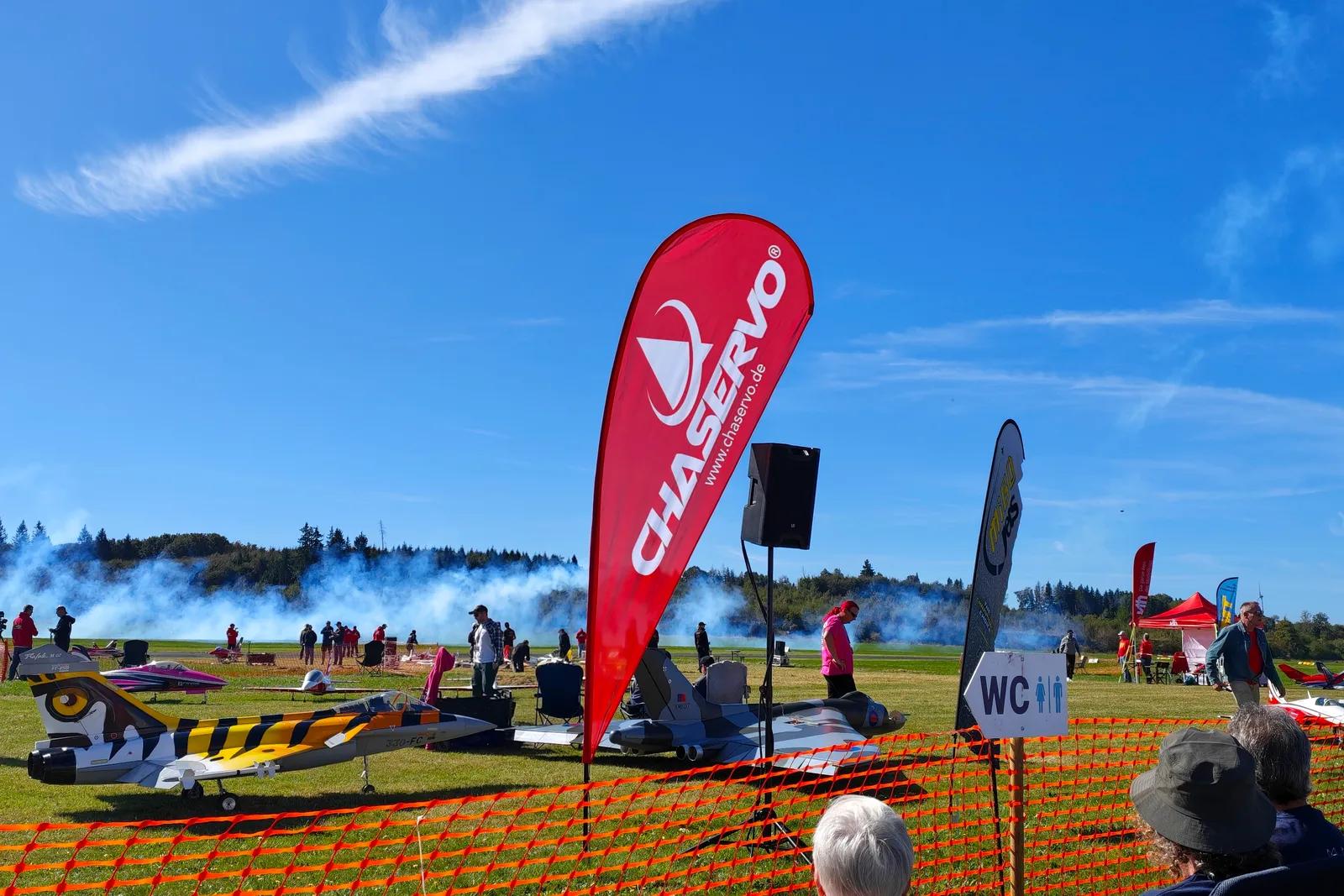 Showflug mit Rauchspur und Modelljets an der Flightline