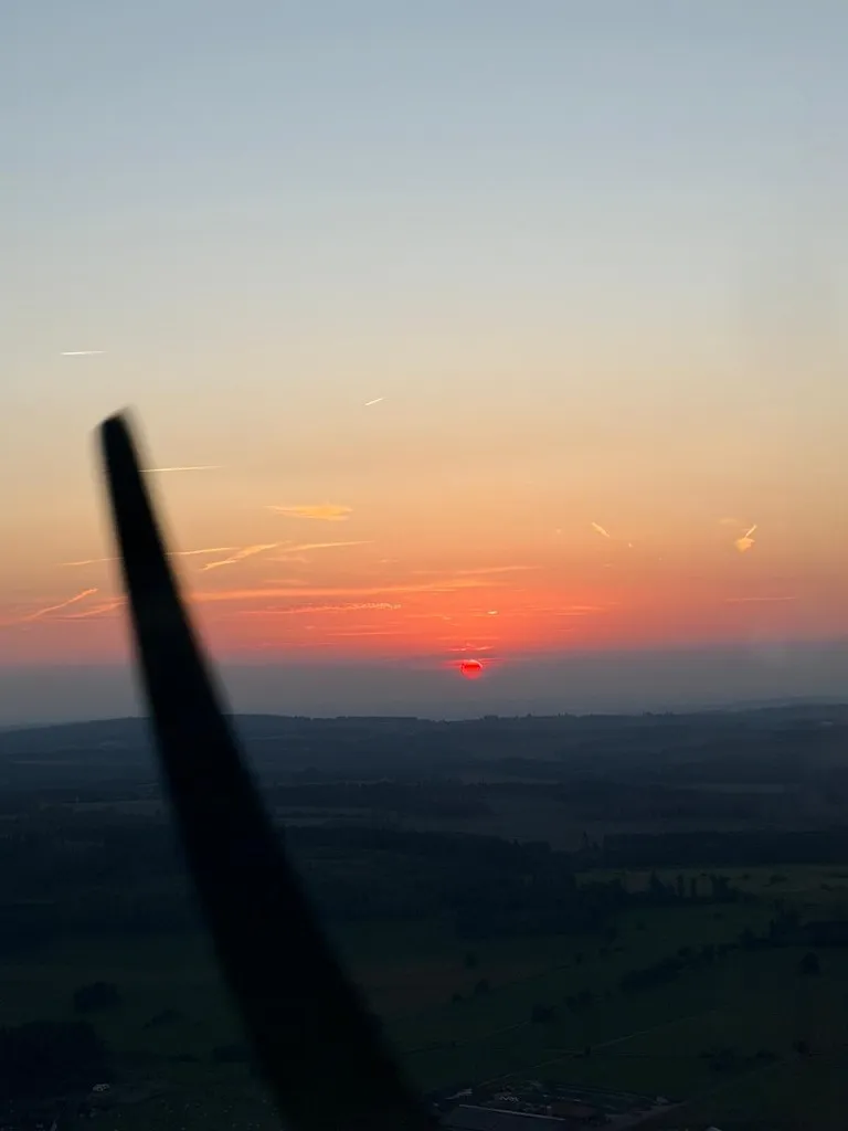 Silhouette der Luftschraube und des Triebwerksraums im tiefroten Sonnenuntergang
